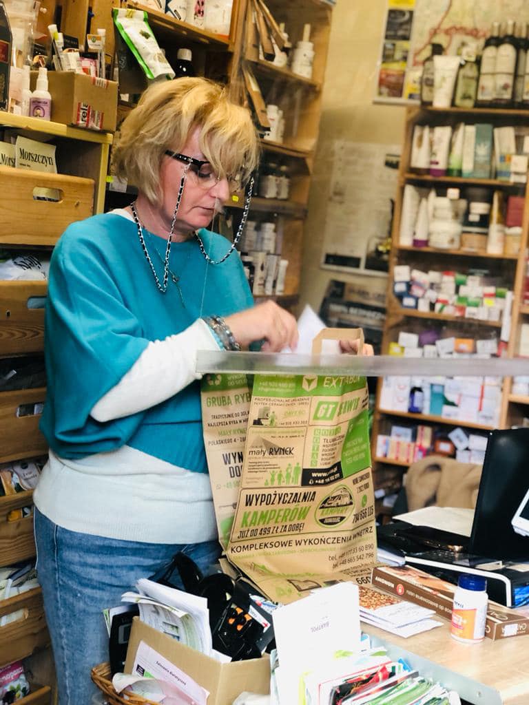 uśmiechnięta sprzedawczyni pakuje warzywa do torby extrabox